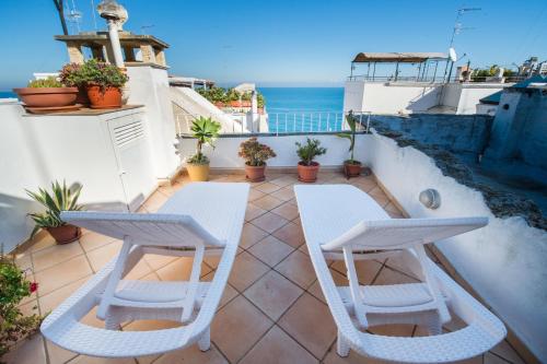 a balcony with two white chairs and the ocean at B&B Casa Dorsi in Polignano a Mare