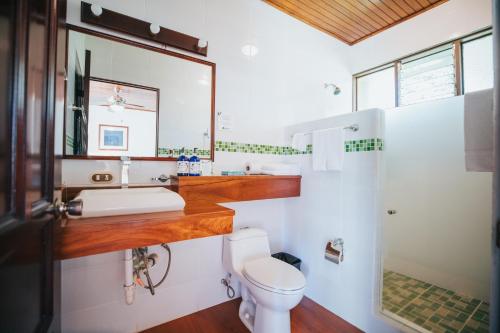 uma casa de banho com um lavatório e um WC em Tilajari Hotel Resort em La Fortuna