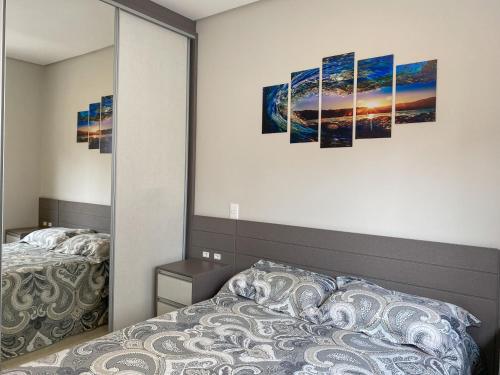 a bedroom with a bed and a mirror at Apartamento encantador com piscina na Praia de Palmas Governador Celso Ramos in Governador Celso Ramos
