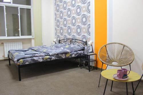 um quarto com uma cama, uma cadeira e uma mesa em Uneed Rooms Somnium em Kiev