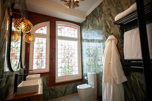 a bathroom with two sinks and two windows at Storytellers Palace in São Martinho do Porto