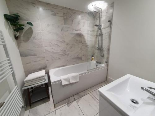 a white bathroom with a tub and a sink at Riverdale House(4 Bedrooms) Serviced Accommodation in Grimsby