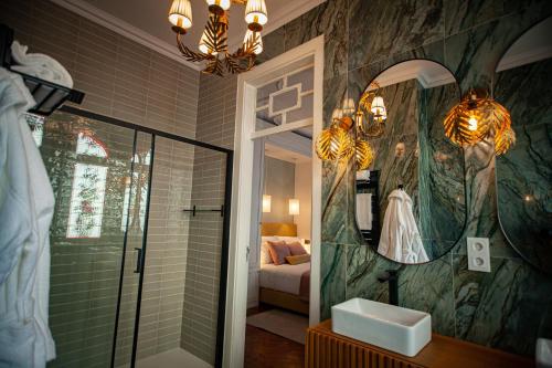 a bathroom with a shower and a sink and a mirror at Storytellers Palace in São Martinho do Porto