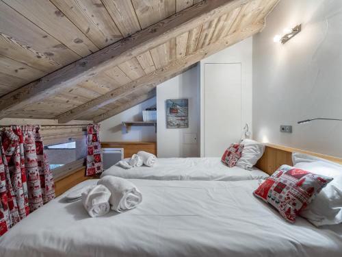two beds in a room with wooden ceilings at Appartement cosy au pied des pistes avec mezzanine, poêle à bois et services inclus pour 4 personnes - FR-1-570-28 in Saint-Martin-de-Belleville