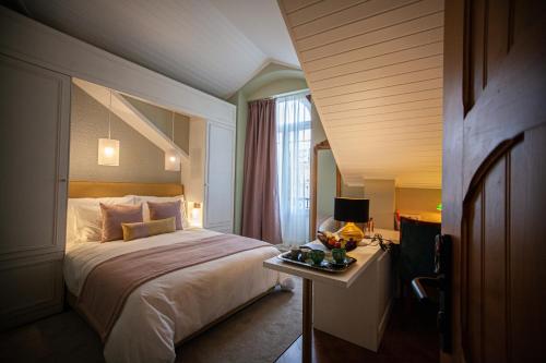 um quarto de hotel com uma cama e uma mesa com um prato de comida em Storytellers Palace em São Martinho do Porto