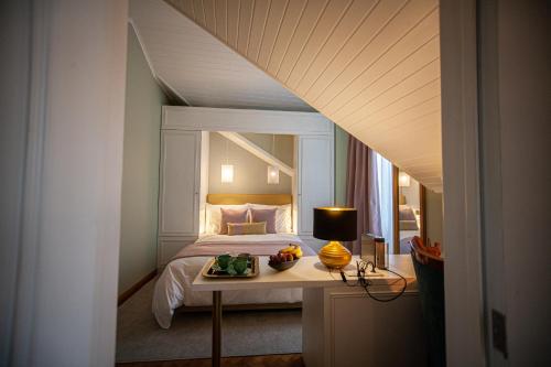 a bedroom with a bed and a table with a lamp at Storytellers Palace in São Martinho do Porto