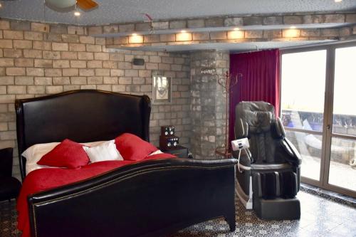 1 dormitorio con cama negra y almohadas rojas en The Royal Suite, en Safed