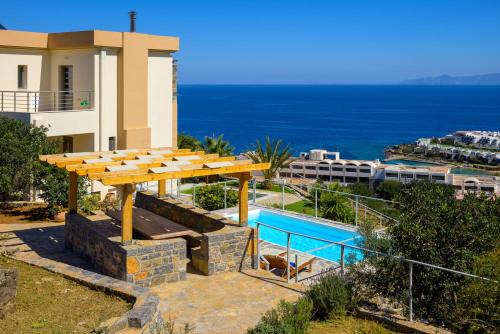 een villa met uitzicht op een zwembad bij Villa Calypso Elounda in Elounda