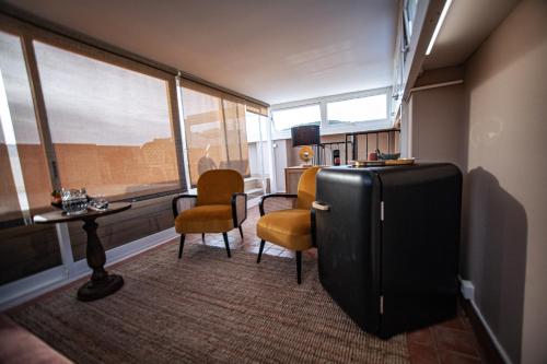 a room with chairs and a refrigerator and a table at Storytellers Palace in São Martinho do Porto