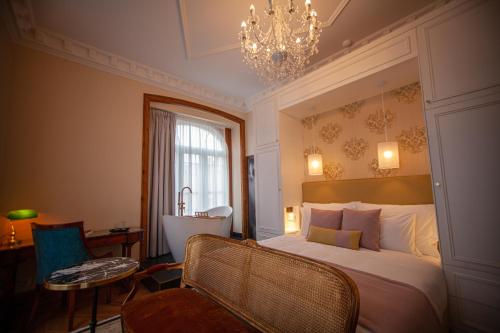 a bedroom with a large bed and a chandelier at Storytellers Palace in São Martinho do Porto