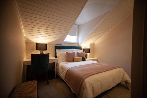 a bedroom with a bed with a desk and a window at Storytellers Palace in São Martinho do Porto