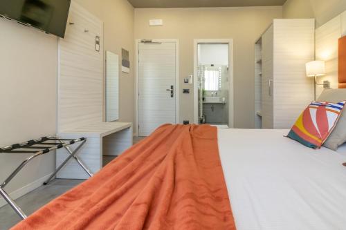 a bedroom with a bed with an orange blanket on it at Cinque Terre Gateway in La Spezia