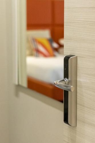 a door with a door handle in a room with a bed at Cinque Terre Gateway in La Spezia