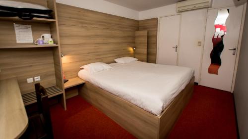 ein kleines Schlafzimmer mit einem Bett in einem Zimmer in der Unterkunft So'Lodge Niort A83 in La Creche
