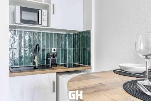 - une cuisine avec évier et verre de vin dans l'établissement Le P’tit Bussy - Magnifique studio proche Disneyland & Paris, à Bussy-Saint-Georges