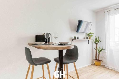 une table à manger avec deux chaises et une télévision dans l'établissement Le P’tit Bussy - Magnifique studio proche Disneyland & Paris, à Bussy-Saint-Georges