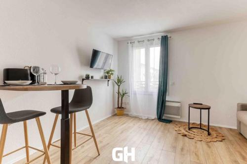 un salon avec une table, des chaises et un canapé dans l'établissement Le P’tit Bussy - Magnifique studio proche Disneyland & Paris, à Bussy-Saint-Georges