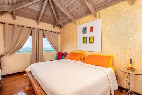 Un dormitorio con una gran cama blanca y una ventana en Vieques Villa Gallega - Oceanview w/Infinity Pool en Vieques