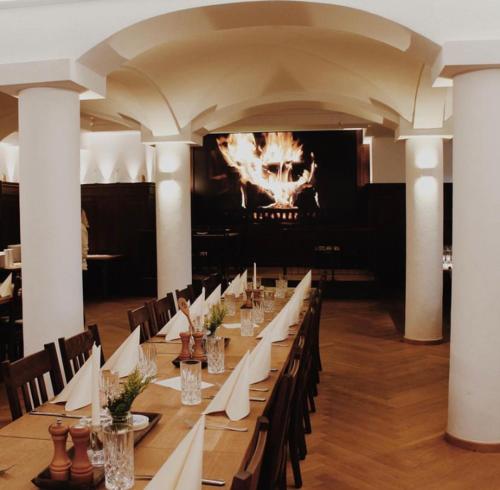 a long dining room with a long table with white napkins at Gasthof & Hotel Bichler in Emmering
