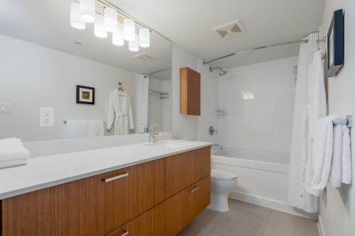 a bathroom with a sink and a tub and a toilet at Level Vancouver Yaletown - Seymour in Vancouver