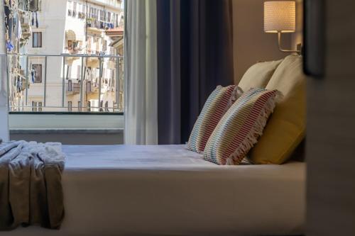 a bed with pillows and a window with a view at Cinque Terre Gateway in La Spezia