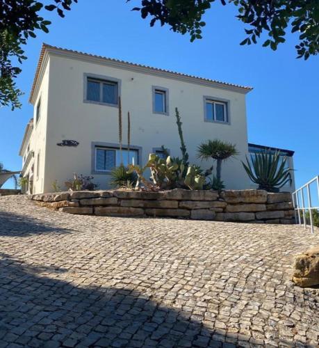 a house with a stone wall in front of it at Casa Tin Tin in Moncarapacho