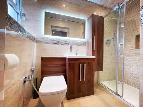 a bathroom with a toilet and a sink and a shower at Luxurious Kitchen, 4BR Home with Free Parking near Airport for Contractor Holiday for 8 People in Luton