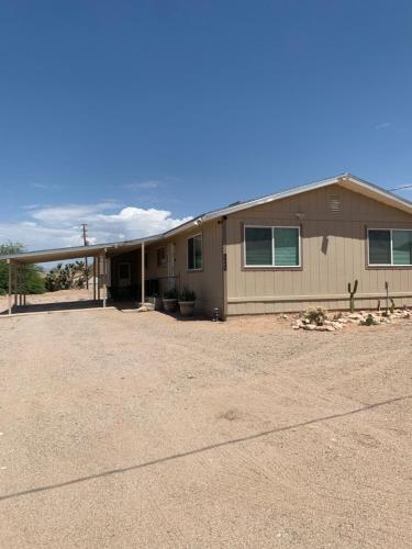 a house in a field with a dirt lot at Rare four Bedroom MeadviewVacation Home - Grand Canyon West-Skywalk in Meadview