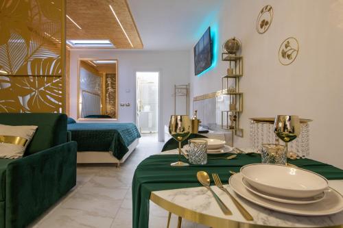 FASHION APARTMENT GOLD Bologna في بولونيا: غرفة معيشة مع أريكة خضراء وطاولة