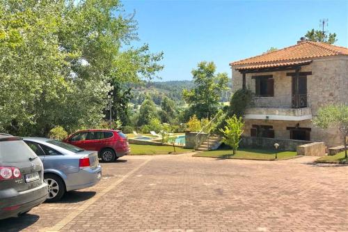 a parking lot with cars parked in front of a house at Ntinos House Elani Halkidiki in Siviri