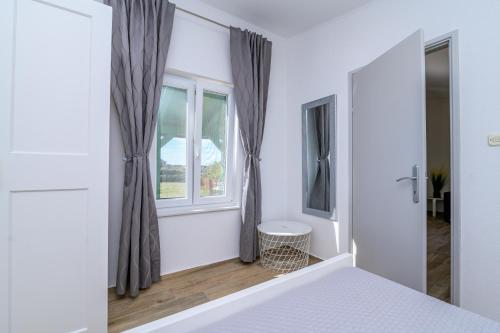 a bedroom with a bed and a window at Krcina Holiday Home in Cres