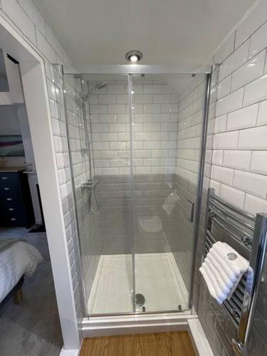 a shower with a glass door in a bathroom at Haven Cottage, Cromer in Cromer