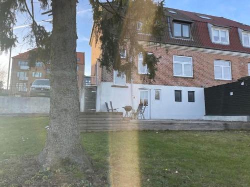 una casa con un árbol delante de ella en H2 Free Parking, budget friendly, en Aalborg