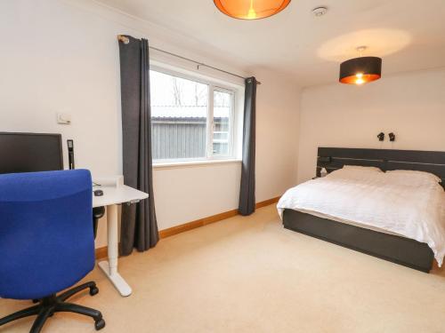 a bedroom with a bed and a desk and a window at Mullingar in Pitlochry