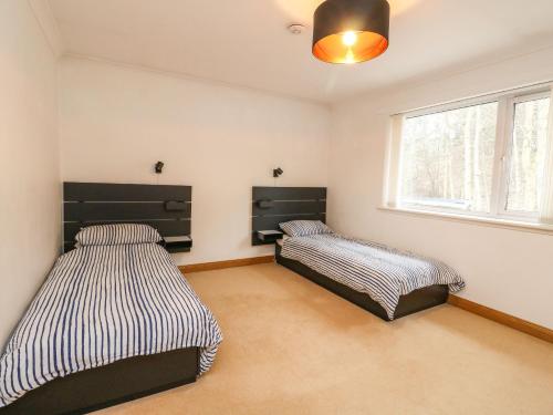 um quarto com 2 camas e uma janela em Mullingar em Pitlochry