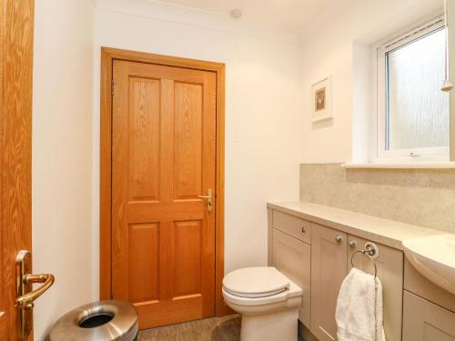 bagno con servizi igienici e porta in legno di Mullingar a Pitlochry