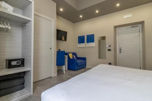 a bedroom with a white bed and a blue chair at Cinque Terre Gateway in La Spezia