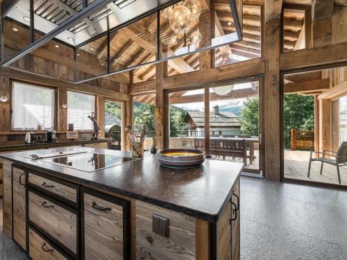 Il comprend une grande cuisine avec des murs en bois et des fenêtres. dans l'établissement Chalet de Luxe à Méribel : Piscine, Hammam et Proximité Télésiège - FR-1-566-5, à Les Allues