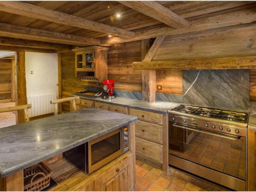 a large kitchen with wooden cabinets and a stove at Chalet Méribel, 6 pièces, 10 personnes - FR-1-566-23 in Les Allues