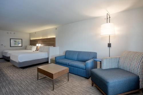 a hotel room with a bed and a bed and a couch at Holiday Inn Express Radcliff Fort Knox by IHG in Radcliff