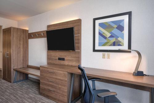 a room with a desk with a television and a chair at Holiday Inn Express Radcliff Fort Knox by IHG in Radcliff