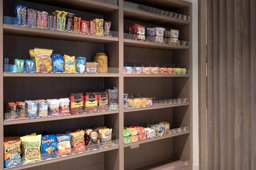 a book shelf filled with lots of different types of food at Holiday Inn Express Radcliff Fort Knox by IHG in Radcliff