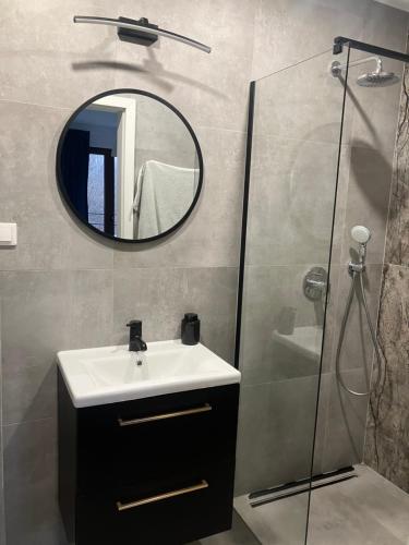 a bathroom with a sink and a mirror at Apartament z balkonem blisko plaży in Niechorze