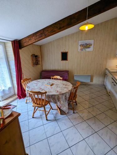 une cuisine avec une table et des chaises dans une pièce dans l'établissement Gîte Aglaé, à Vals-les-Bains