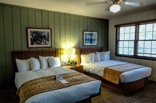 a hotel room with two beds and two windows at POSTOAK Lodge and Retreat in Tulsa