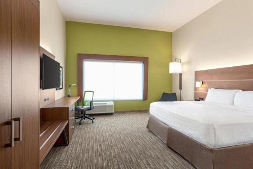 a hotel room with a bed and a flat screen tv at Holiday Inn Express & Suites Austin North - Pflugerville, an IHG Hotel in Pflugerville