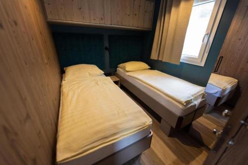 two twin beds in a small room with a window at Camping Nord in Klopein am Klopeiner See