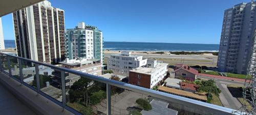 a balcony with a view of a city and the ocean at Jose Luis Arenas del Mar Torre 1 in Punta del Este