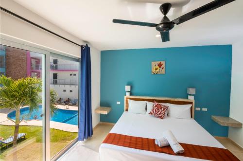 a bedroom with a bed and a swimming pool at Hotel Playa Encantada in Playa del Carmen
