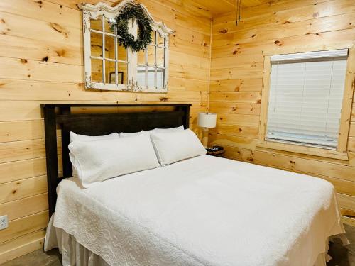 a bedroom with a bed in a wooden wall at Knotty Squirrel Cabins in Mountain View